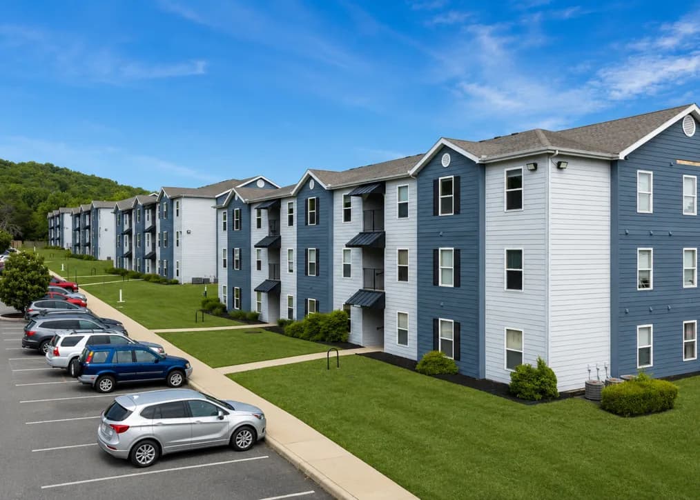Mountain View Apartments exterior: three-story blue and white apartment buildings with lawns and parking